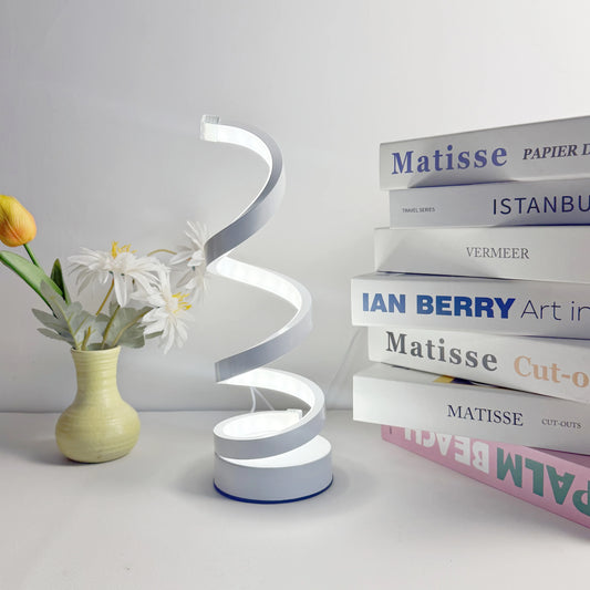 Moderne, elegante, witte spiraalvormige bureaulamp, gevoed via USB met driekleurige dimfunctie, geschikt voor diverse soorten kamers.